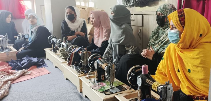 Afghan women sit at sewing machines during vocational training