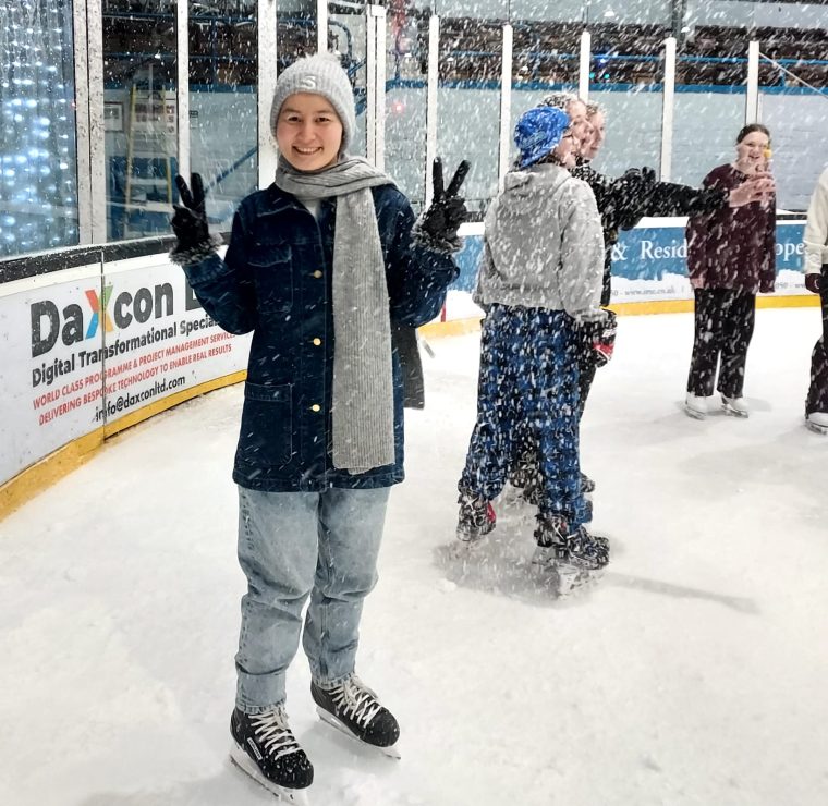 Zahra Hussaini on ice rink, smiling at camera.